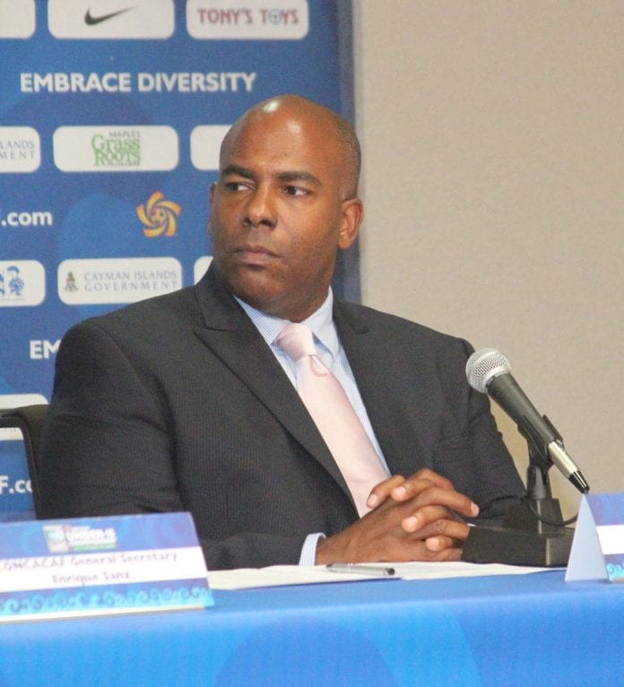 Bruce Blake sitting at desk - Caribbean News Weekly