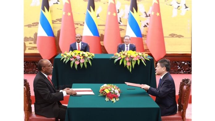 Minister for Health, Wellness, Social Transformation and the Environment, Sir Molwyn Joseph (left) signs an MOU with a representative from Alibaba Damo Academy and Hospitals.