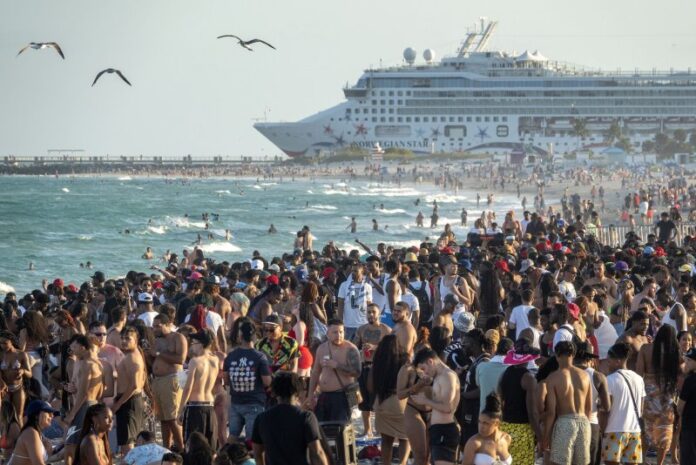 People spend time at the beach during spring break in Miami Beach in 2022. The city in a viral video announced it is 