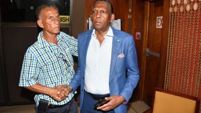 New JCA president Dr Donovan Bennett (left) greets his predecessor Wilford 'Billy' Heaven