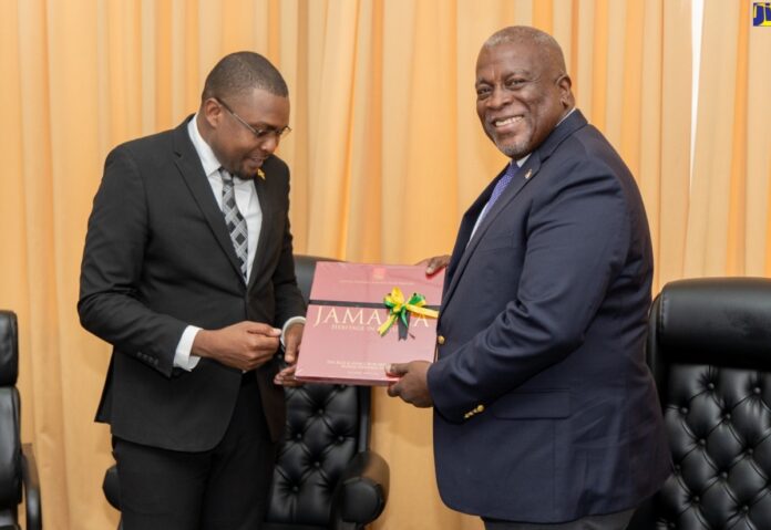Minister without Portfolio in the Office of the Prime Minister with responsibility for Information, Hon. Robert Morgan (left), presents a book entitled ‘Jamaica: Heritage in Pictures’ to Prime Minister of Guyana, Hon. Brigadier (Ret'd) Mark Phillips. Occasion was a meeting at the Prime Minister’s office in Georgetown on Thursday (May 2).