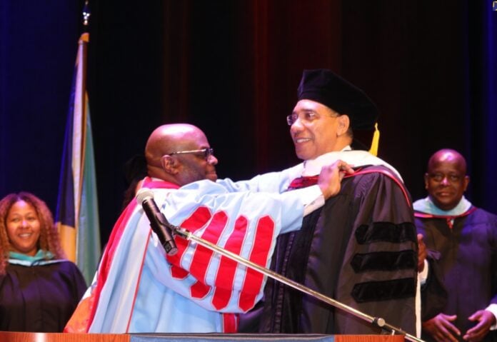 Prime Minister the Most Hon. Andrew Holness (right) is conferred with the honorary degree of Doctor of Humane Letters by the President of Delaware State University, Dr. Tony Allen, at the 2024 commencement ceremony held on Friday (May 10) at the university’s campus in Dover, Delaware.